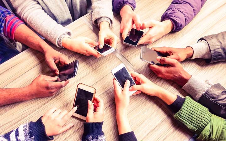 group of hands holding smart phones