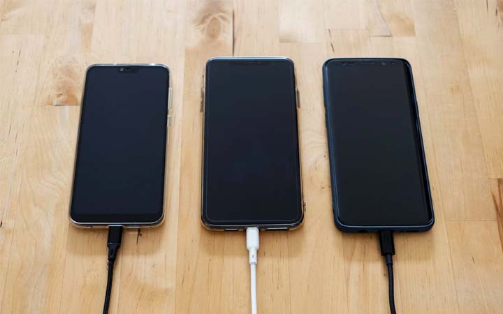three smart phones sitting on a table
